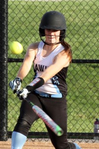 Eighth-grader Maria Rasmusson connects with the ball in the West Marshall game. The designated hitter had one of the Hawks’ 15 hits against the Trojans.