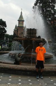 Luke in center of the city of Timisoara, the city where he was born, with an Orthodox Cathedral in the background.