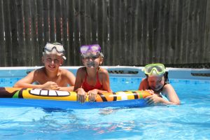 Logan and Jenna Allbee and Nicole Johnson find a cool way to beat the heat by swimming in the Allbees’ Sully residential pool.