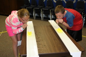 Alyssa Bassett and Noah Johnson compete in a boat race.