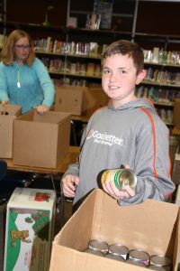 Noah Johnson and Abby Squires package boxes with food for Sharing Tree recipients.